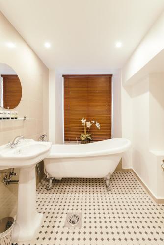 a bathroom with a tub and a sink and a window at Merchants House Hotel in Tallinn
