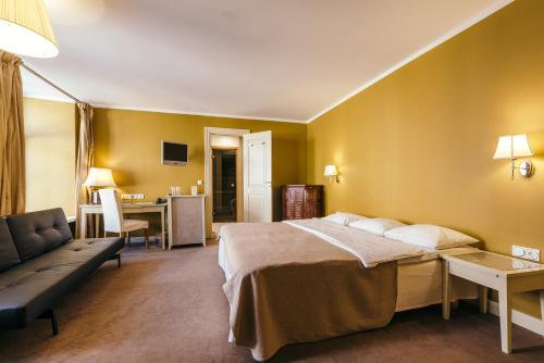 a hotel room with a bed and a couch at Merchants House Hotel in Tallinn