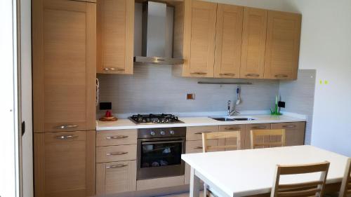 a kitchen with wooden cabinets and a stove at Appartamento Nature Il Colle in Marciana