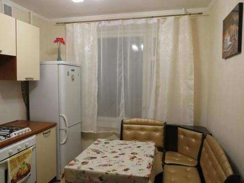 uma pequena cozinha com uma mesa e um frigorífico branco em City Inn Apartments - Baumanskaya em Moscou