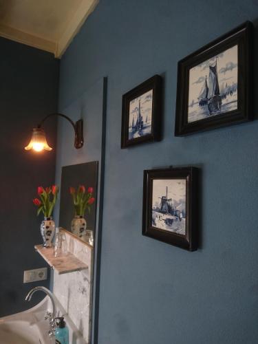 a bathroom with pictures of ships on the wall at Deventer Heritage en Boutique B&B, museumhuis "De Worp", het huis met de theekoepel, logeren in authentiek historisch erfgoed in Deventer
