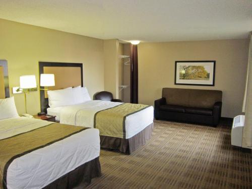 a hotel room with two beds and a chair at Extended Stay America Suites - Memphis - Germantown West in Memphis