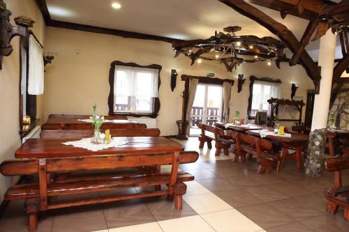 a dining room with wooden tables and chairs at Gościniec Legenda in Wyszogród