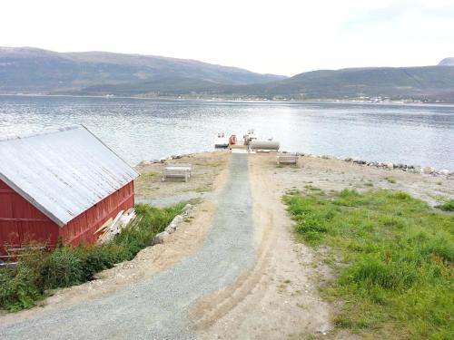 a dirt road next to a body of water at Hansnes Havfiske in Hansnes