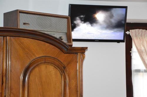 a flat screen tv sitting on top of a bed at Szent Iván Vendégház in Tata
