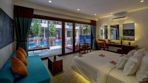 a bedroom with a large white bed and a desk at Golden Temple Retreat in Siem Reap