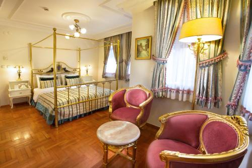 1 dormitorio con 1 cama con dosel y 2 sillas en Valide Sultan Konagi, en Estambul