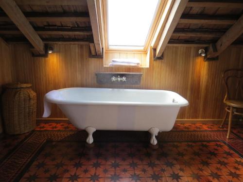 a white bath tub in a bathroom with a window at Hotel Boutique Casa Werner in Puerto Varas