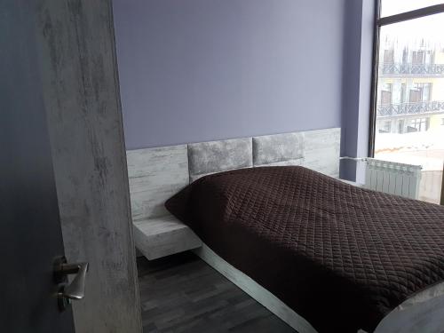 a bed sitting in a room with a window at Apartment in Snow Plaza 49 in Bakuriani