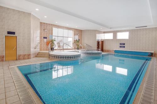 uma grande piscina com banheira num quarto de hotel em Leonardo Hotel Inverness em Inverness