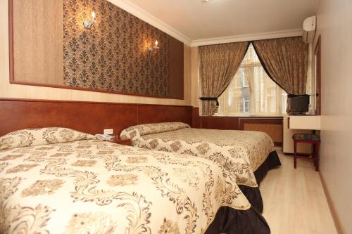 Cette chambre comprend deux lits et une télévision. dans l'établissement Turvan Hotel, à Istanbul