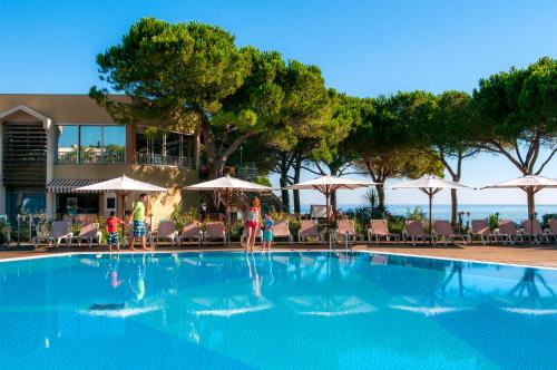 une piscine avec chaises et parasols dans l'établissement Le Village des Isles, à Taglio-Isolaccio