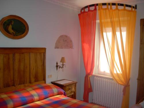 un dormitorio con una cama y una ventana en Bricco Dei Ciliegi, en Cortazzone