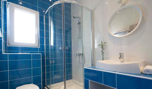 a blue and white bathroom with a sink and a mirror at Apartments Denis in Makarska