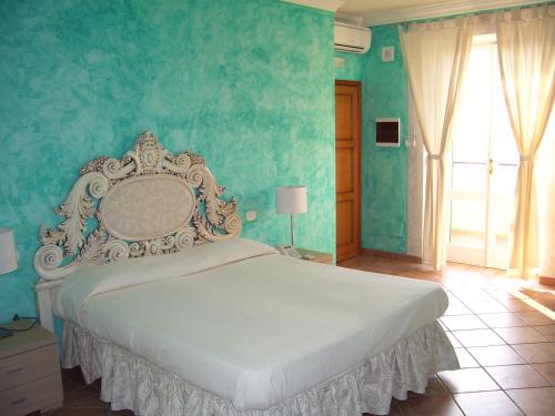 a bedroom with a large bed with blue walls at Casale Sant'Angelo in Capalbio
