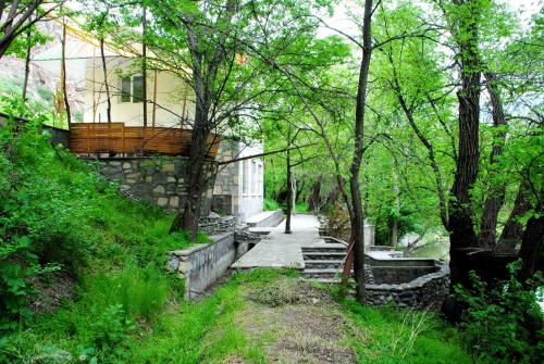a path in a park with a building and trees at Park-Hotel Khoren's Lake in Areni