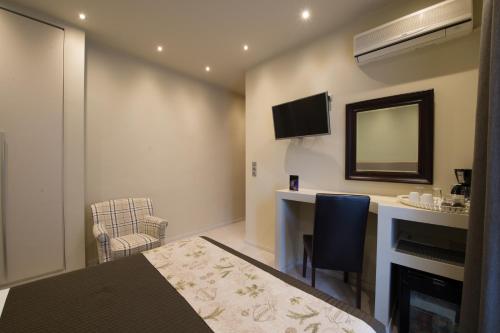a hotel room with a desk and a mirror at Filoxenia Hotel & Spa in Kalavrita