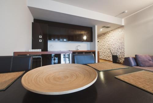 a dining room with a table and a kitchen at Hotel Hemingway Residence in Bucharest