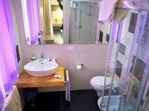 bagno con lavandino, servizi igienici e specchio di B&B Villa Letizia Inn a Castelbuono