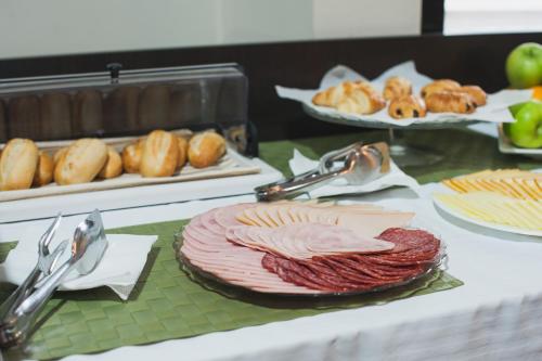 a table topped with meats and breads and other foods at Hotel Hemingway Residence in Bucharest