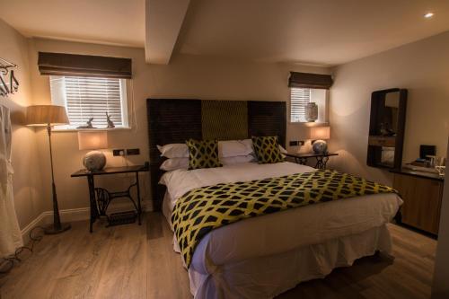 a bedroom with a large bed and two night stands at The Peacock at Barlow in Chesterfield