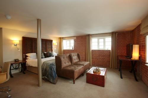 a hotel room with a bed and a chair at Salthouse Harbour Hotel in Ipswich