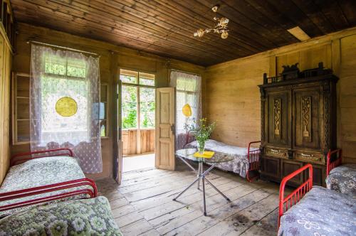 a room with two beds and a table and windows at Kalistine Ethnography House in K'veda Kinch'kha
