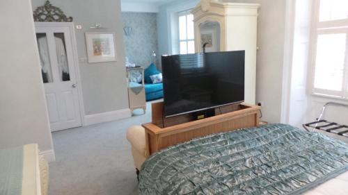 a living room with a flat screen tv on a stand at The Somerville in Torquay