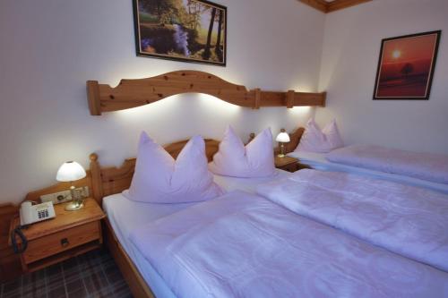 two beds in a bedroom with white pillows at Appartementhaus Sonne in Ramsau am Dachstein