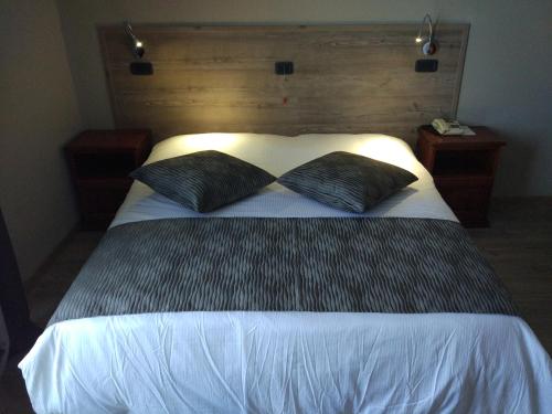 a bedroom with a large bed with two black pillows at Albergo Ristorante San Biagio in Montepulciano
