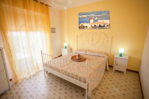 a small bedroom with a bed and two lamps at Appartamenti Corollai in Trapani