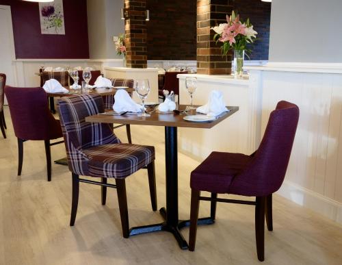 a table with chairs and wine glasses on it at The Crown Hotel in Newton Stewart
