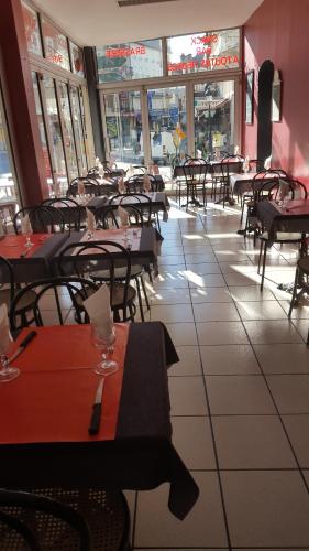 un comedor vacío con mesas y sillas en un restaurante en Hôtel du Château Fort, en Lourdes