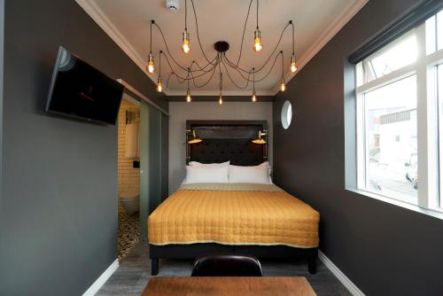 a bedroom with a bed and a chandelier at 105 - A Townhouse Hotel in Reykjavík