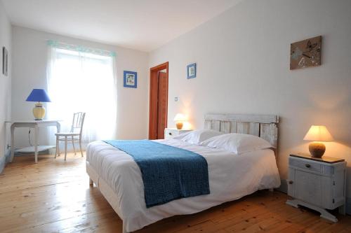 a bedroom with a bed with a blue blanket on it at Maison D'hôtes Du Landersbach in Sondernach