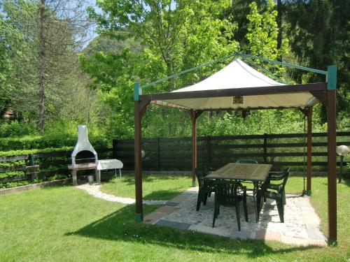 a gazebo with a table and chairs and a grill at Casa Max in Ledro