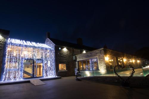 a building decorated with christmas lights at night at The Peacock at Barlow in Chesterfield