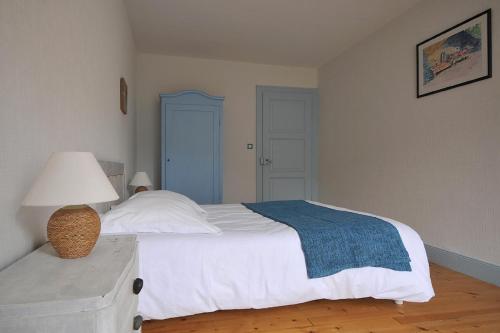 a bedroom with a bed and a lamp on a dresser at Maison D'hôtes Du Landersbach in Sondernach