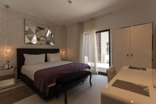 a bedroom with a bed and a dresser and a desk at Nacala Plaza Business Design Hotel in Cidade de Nacala