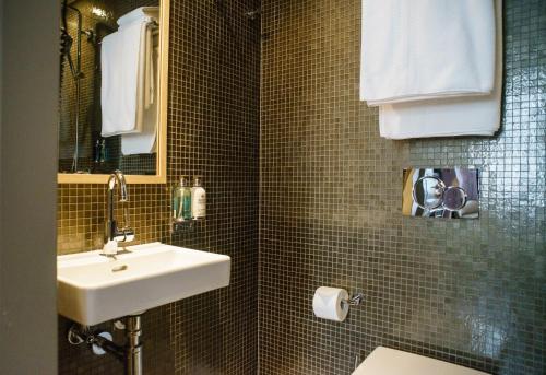 a bathroom with a sink and a toilet and a mirror at Mimi's Hotel Soho in London