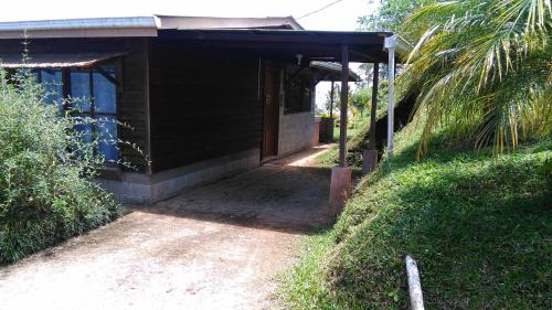 a small building with a porch and a door at Finca Y Granja Loma Bonita in Turrialba