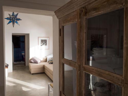 a living room with a couch and a mirror at Dammuso sulla scogliera - Pantelleria in Scauri