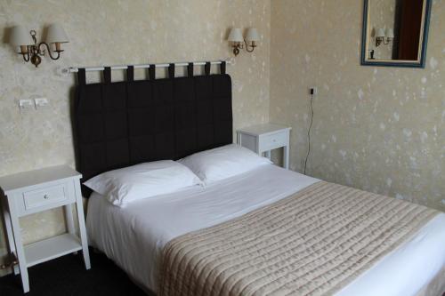 a bed with a black headboard in a bedroom at Hôtel Moderne in Gisors