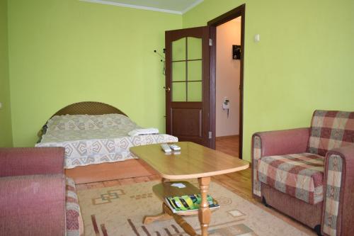 a living room with a table and a bed at Apartment on Vasylya Chervoniya 67 in Rivne