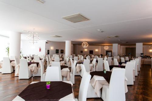 a banquet hall with white tables and white chairs at Hotel Scialì in Vieste