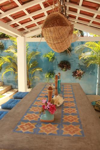 a table with flowers and a basket on top of it at Canto das Laranjeiras Villa in Guarujá