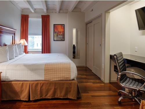 a bedroom with a bed and a desk and a chair at Grand Eastonian Hotel & Suites in Easton