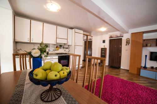 ティミショアラにあるRox Central Apartmentsのキッチン(テーブルの上にフルーツを盛り付けた器付)