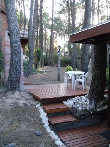 a wooden deck with a table and chairs on it at Cabañas El Ocio in Mar de las Pampas