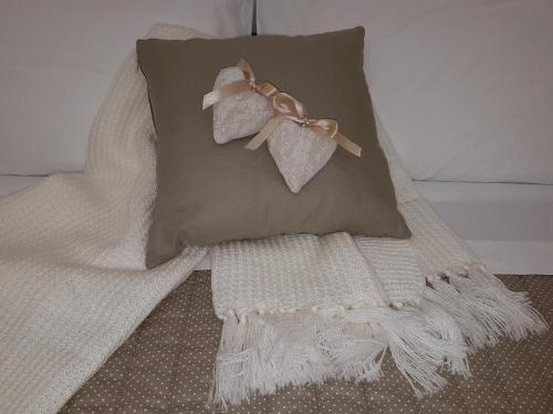 a pillow with bows on it sitting on a bed at Finestre sul Borgo in Cassano delle Murge